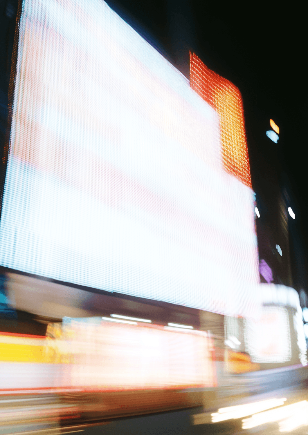 Long-exposure lights from a giant city screen at night