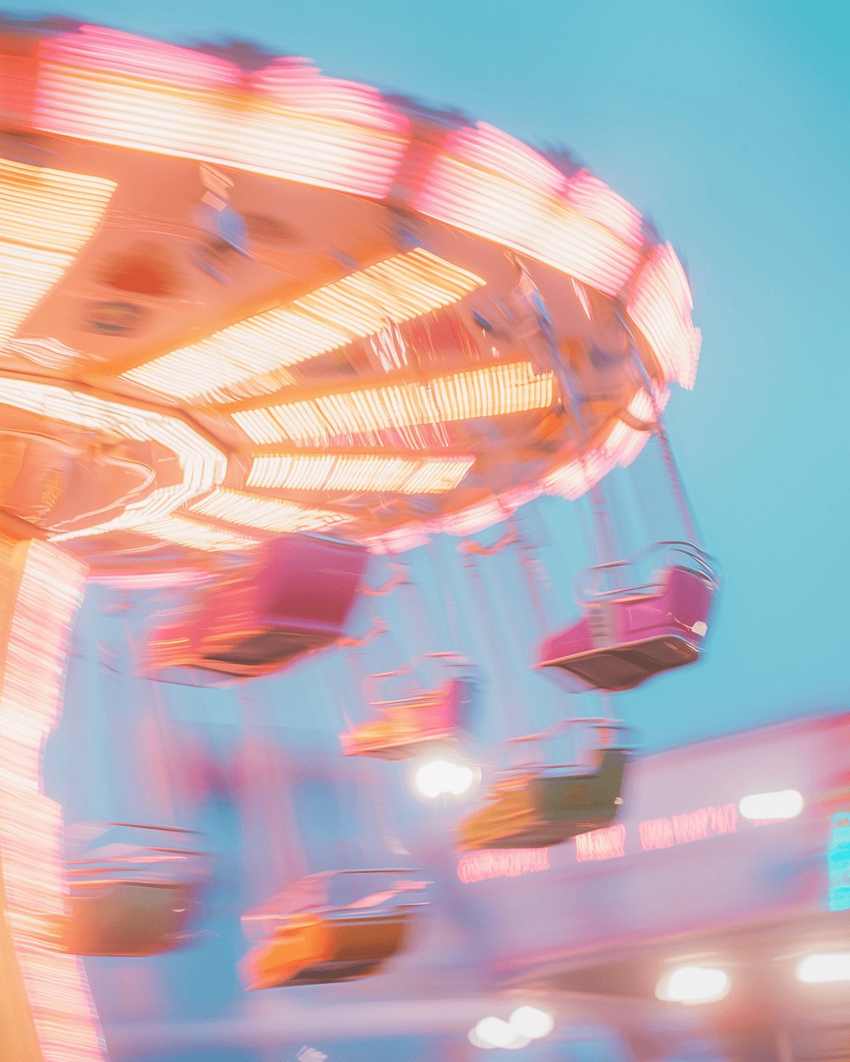 A neon swing ride blurred into ribbons of light